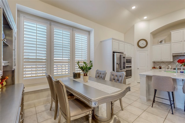 dining room with vaulted ceiling and light tile patterned flooring