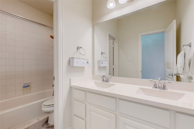 full bathroom featuring toilet, tiled shower / bath combo, and vanity