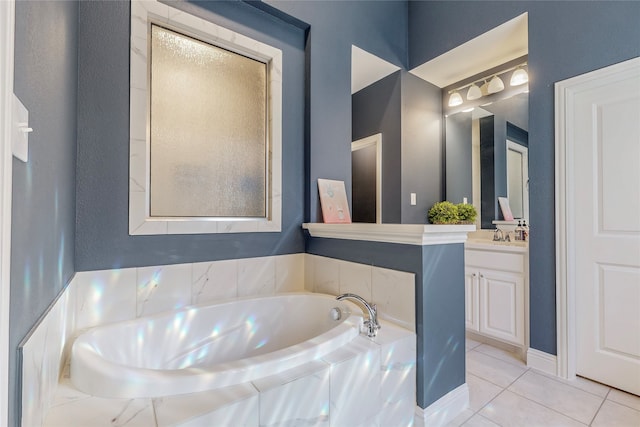 bathroom featuring vanity, tiled tub, and tile patterned flooring