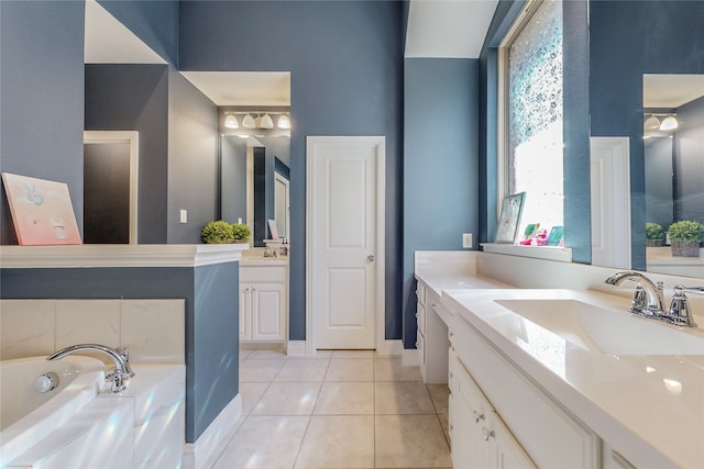 bathroom with a washtub, tile patterned floors, and vanity