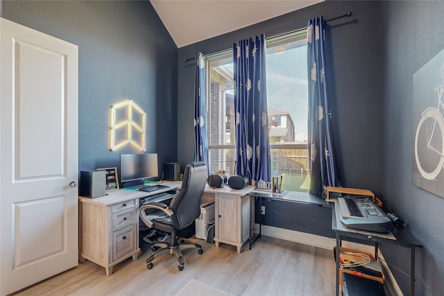 office space featuring light hardwood / wood-style flooring, vaulted ceiling, and plenty of natural light