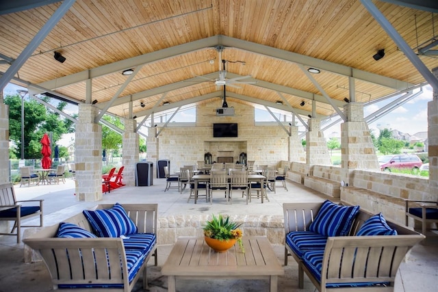 view of patio / terrace with a gazebo, ceiling fan, and an outdoor living space with a fireplace