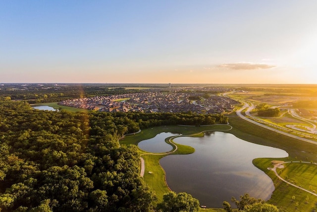 aerial view at dusk featuring a water view