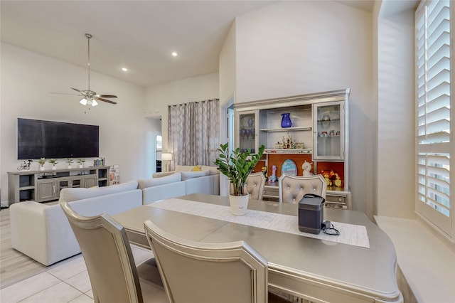 tiled dining space with a high ceiling, ceiling fan, and plenty of natural light