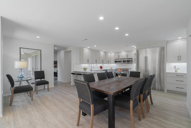 dining space featuring light hardwood / wood-style floors and sink