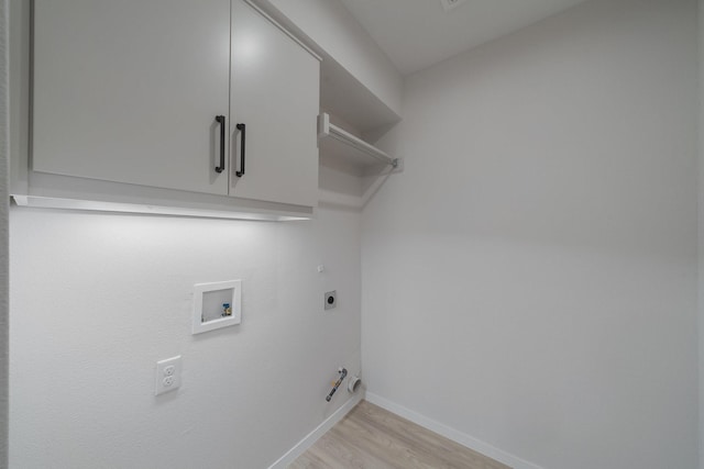 washroom with cabinets, hookup for a gas dryer, electric dryer hookup, light hardwood / wood-style floors, and hookup for a washing machine