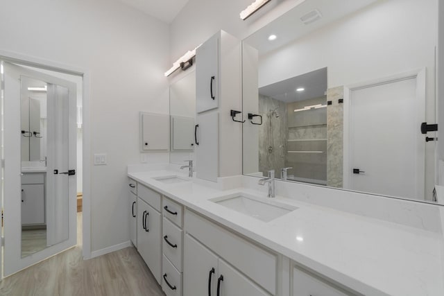 bathroom featuring wood-type flooring, an enclosed shower, and vanity