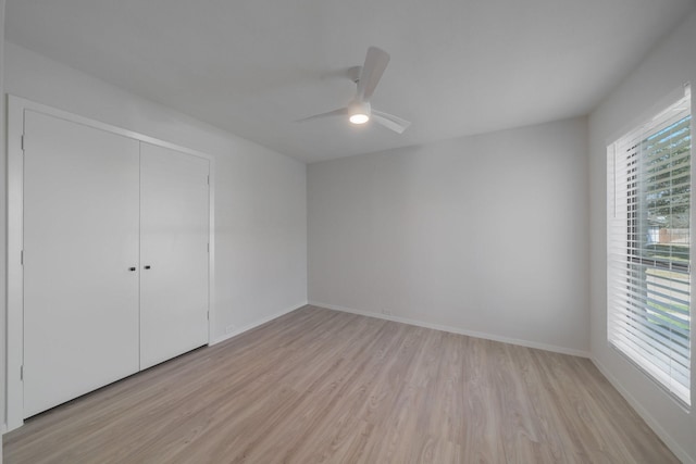 unfurnished bedroom with ceiling fan, a closet, and light wood-type flooring