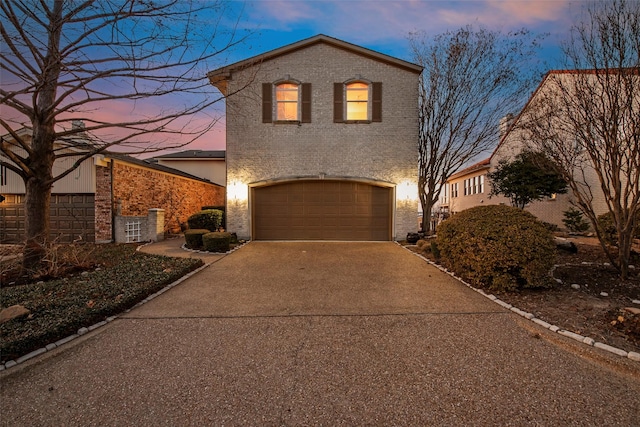 view of front of property with a garage, driveway, and brick siding