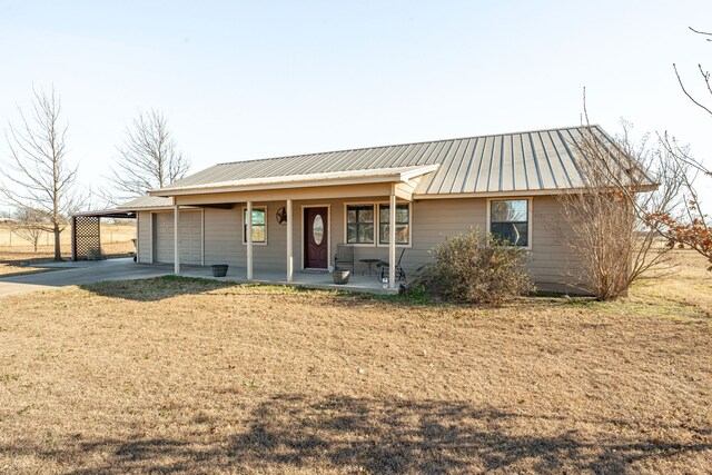 single story home with a garage, covered porch, and a front lawn