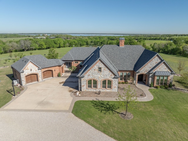 french country style house with a front yard and a garage