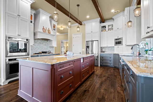 kitchen featuring custom exhaust hood, pendant lighting, a large island, white cabinetry, and beamed ceiling