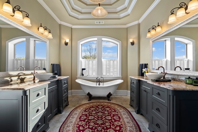 bathroom with ornamental molding, a bathtub, vanity, and a tray ceiling