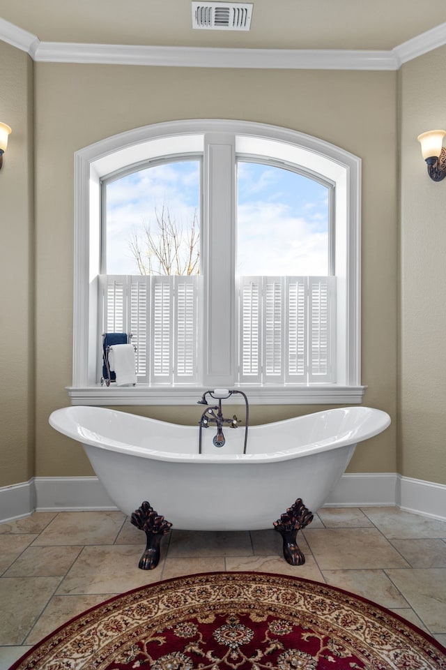 bathroom featuring a wealth of natural light, a bathtub, and crown molding