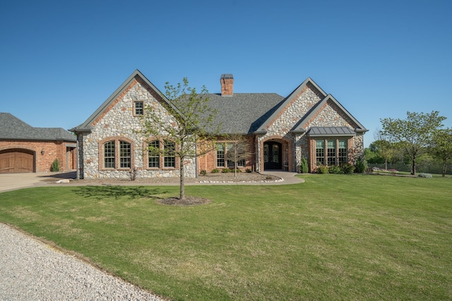 english style home featuring a front lawn and a garage