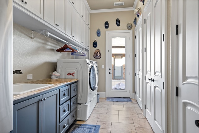 clothes washing area with washing machine and dryer, cabinets, crown molding, light tile patterned flooring, and sink