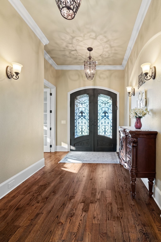 foyer featuring ornamental molding, french doors, a notable chandelier, and hardwood / wood-style flooring