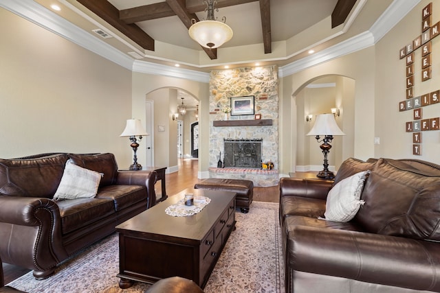 living room featuring coffered ceiling, light hardwood / wood-style flooring, crown molding, a fireplace, and beamed ceiling