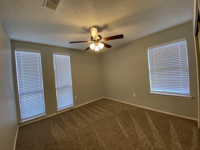 carpeted empty room featuring ceiling fan and a textured ceiling