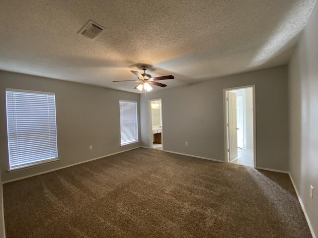 carpeted empty room with ceiling fan and a textured ceiling