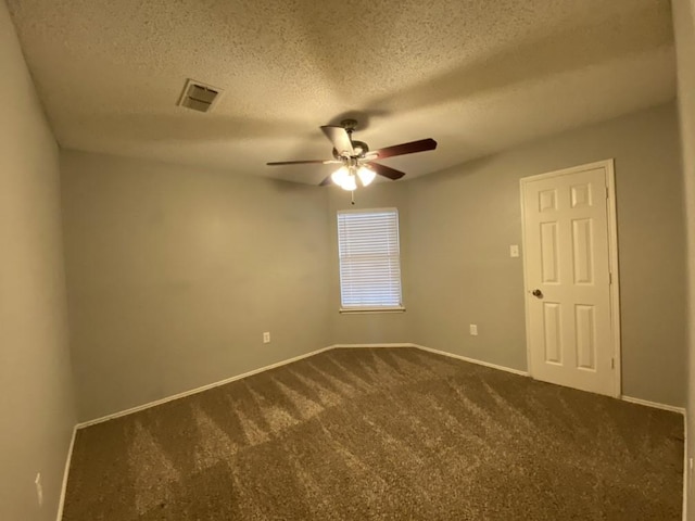 carpeted spare room featuring a textured ceiling and ceiling fan