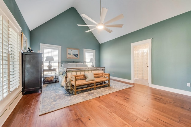 bedroom featuring ensuite bathroom, hardwood / wood-style floors, ceiling fan, and vaulted ceiling