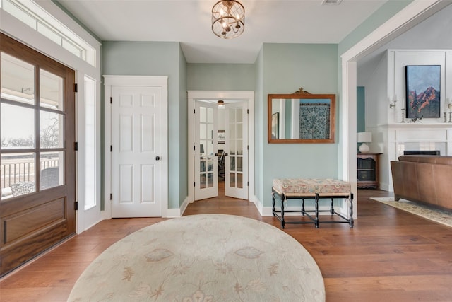 entryway with an inviting chandelier, french doors, wood-type flooring, and plenty of natural light