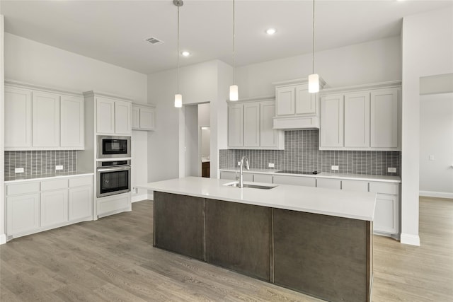 kitchen with white cabinets, black appliances, pendant lighting, and sink