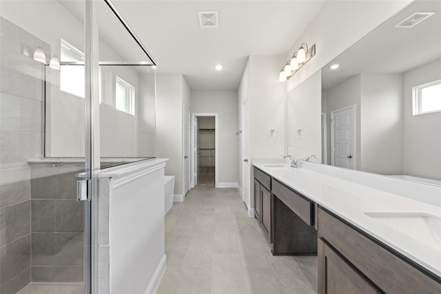 bathroom featuring tile patterned flooring, a shower with door, and vanity