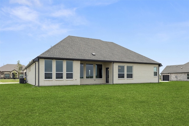 back of house featuring central AC unit and a lawn