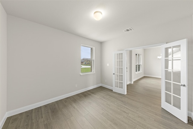 unfurnished room featuring light hardwood / wood-style flooring and french doors