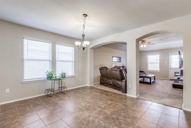 dining room with ceiling fan with notable chandelier and carpet flooring