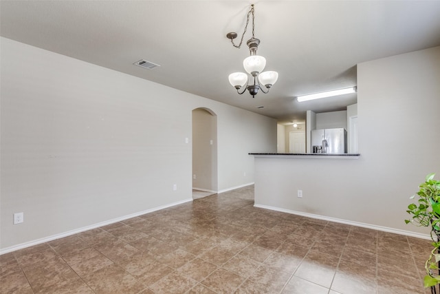 spare room with an inviting chandelier