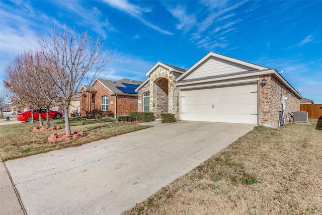 ranch-style home featuring a front lawn, a garage, cooling unit, and solar panels