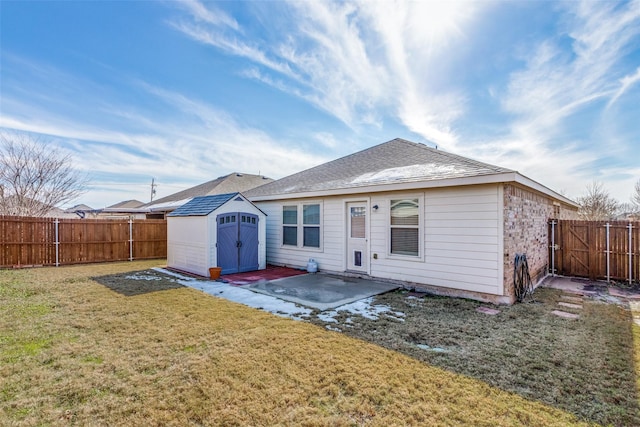 rear view of property with a patio area, a lawn, and a storage unit