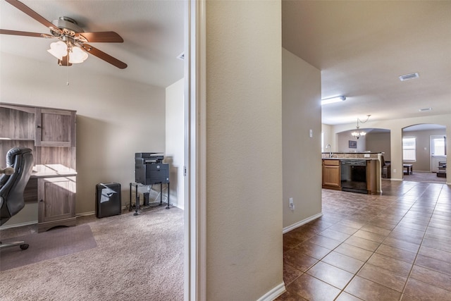 office space featuring carpet floors, sink, ceiling fan with notable chandelier, and lofted ceiling