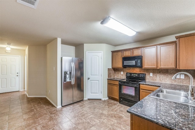 kitchen featuring sink, a textured ceiling, black appliances, and tasteful backsplash