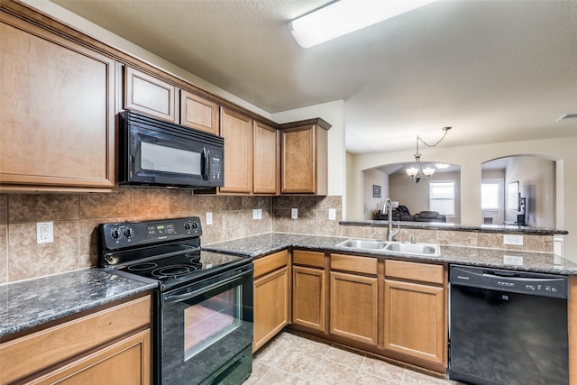 kitchen featuring decorative backsplash, dark stone countertops, a chandelier, black appliances, and sink