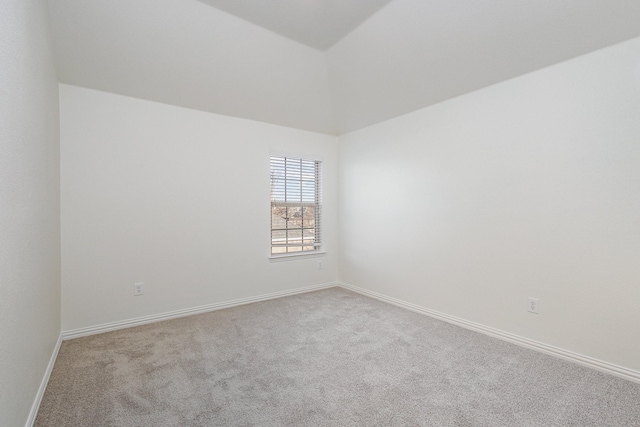 carpeted empty room featuring lofted ceiling