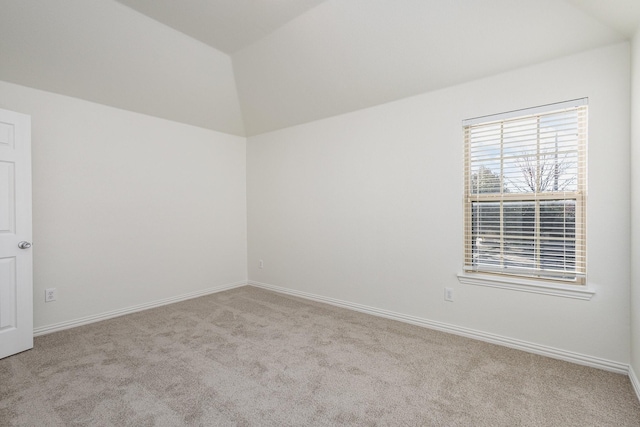 unfurnished room featuring vaulted ceiling and light carpet