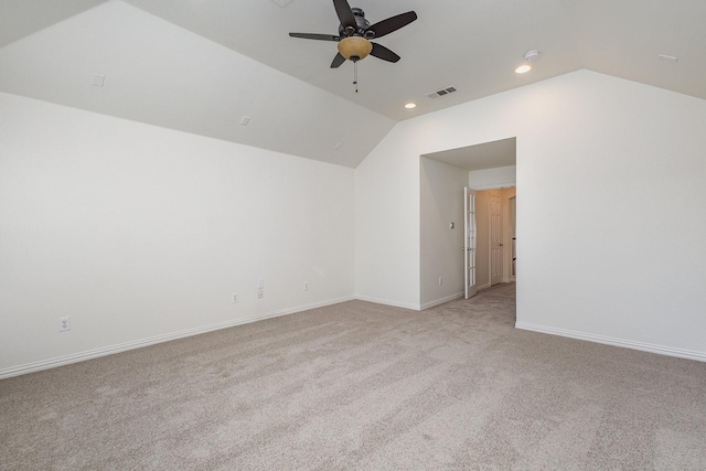 empty room featuring lofted ceiling, light colored carpet, and ceiling fan