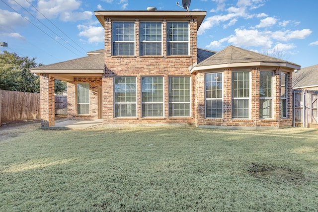 back of house with a patio area and a lawn