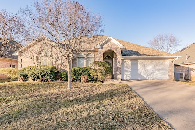 view of front of property with central AC unit, a garage, and a front lawn