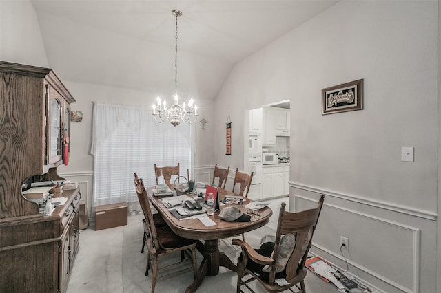 dining space featuring light colored carpet, lofted ceiling, and a chandelier