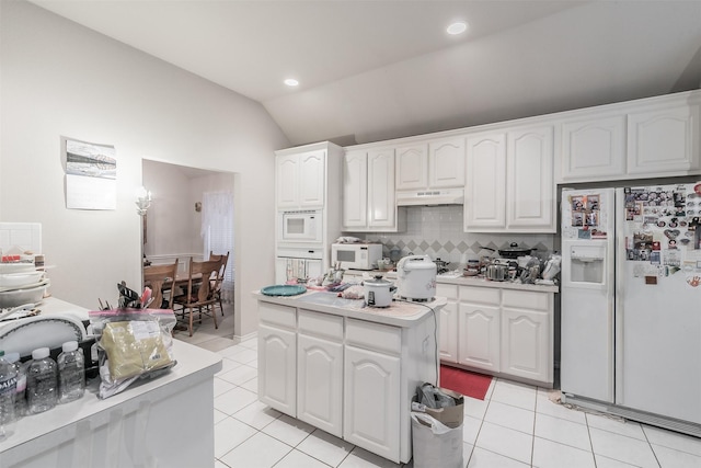 kitchen with white appliances, white cabinetry, and lofted ceiling