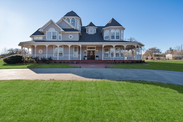 victorian-style house featuring a front yard and a porch