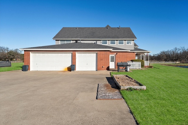 rear view of house featuring a garage and a yard