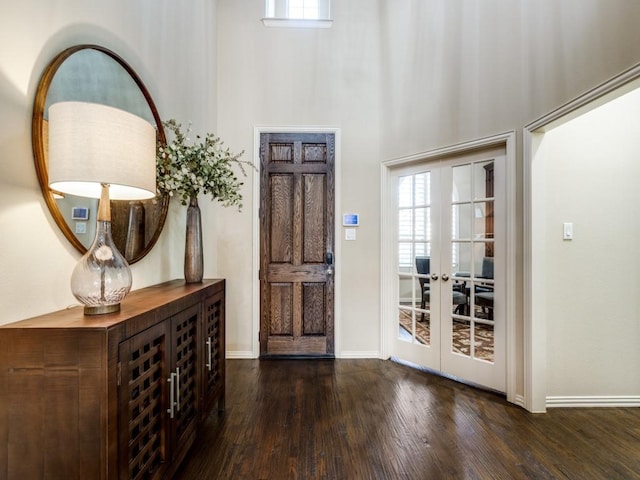 entryway featuring a towering ceiling, french doors, and dark hardwood / wood-style flooring