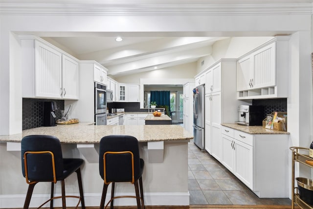 kitchen with a kitchen breakfast bar, lofted ceiling with beams, and kitchen peninsula