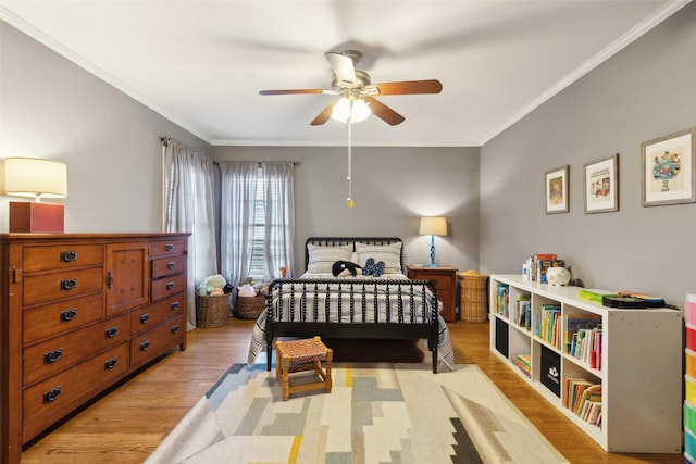 bedroom featuring light wood-type flooring, ceiling fan, and crown molding